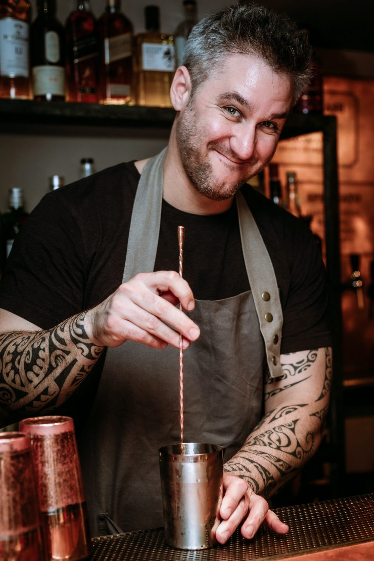 Gregory Buda stirring a cocktail behind the bar